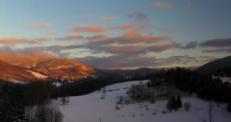 Luftaufnahme-Von-Schneebedeckten-Bergen-Und-Wäldern-Bei-Sonnenuntergang-Im-Winter-9