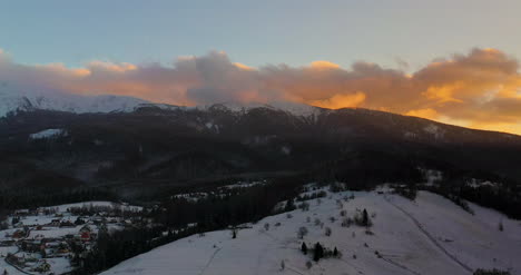 Luftaufnahme-Von-Schneebedeckten-Bergen-Und-Wäldern-Bei-Sonnenuntergang-Im-Winter-2