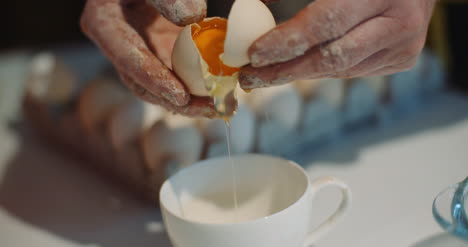 Woman-Breaking-Egg-Into-Bowl-In-Kitchen