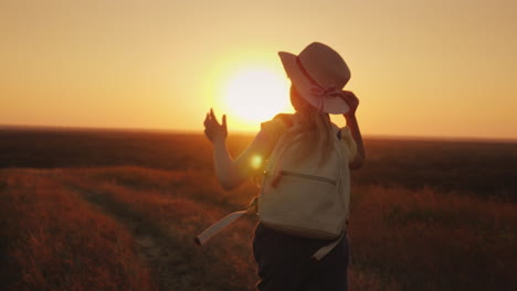 Funny-Girl-In-A-Straw-Hat-Runs-Down-The-Hill-At-Sunset-Holds-The-Hat-With-His-Hands-Leto-And-The-Vac