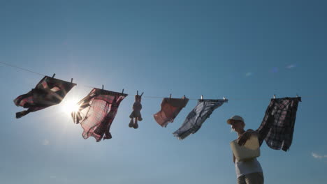 A-Woman-With-A-Basket-Looks-Like-Hanging-Wet-Clothes-On-A-Rope-4K-Video