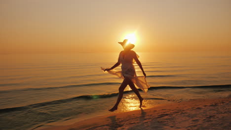 A-Woman-In-A-Light-Dress-Carelessly-Walks-Along-The-Seashore-At-Sunset