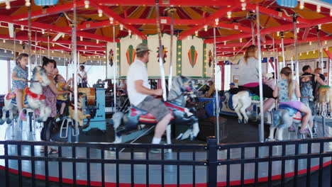 Children-With-Parents-Ride-On-An-Old-Carousel-At-The-Fair