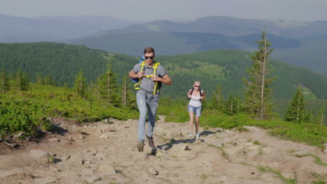 A-Man-And-A-Woman-With-Backpacks-Quickly-Run-Up-The-Mountain-Path-Extreme-Loads-And-Endurance-4K-Vid