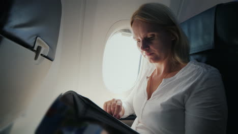 A-Young-Woman-Is-Reading-A-Magazine-In-The-Cockpit-Of-An-Airplane-Comfort-And-Entertainment-In-The-J