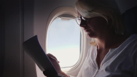 Business-Woman-Is-Reading-Documents-On-The-Plane-Business-And-Travel