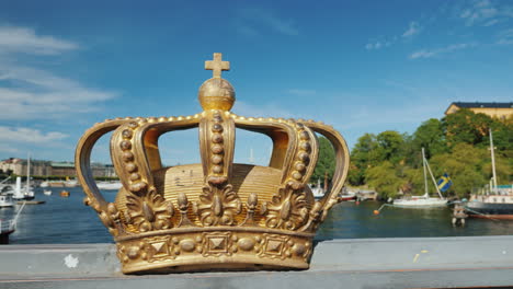 Königliche-Schwedische-Krone-Auf-Der-Brücke-über-Den-Fluss-Mit-Hafen-Im-Hintergrund-Eine-Der-Sehenswürdigkeiten-Von