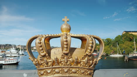 Königliche-Schwedische-Krone-Auf-Der-Brücke-über-Den-Fluss-Mit-Hafen-Im-Hintergrund-Eine-Der-Sehenswürdigkeiten-Von