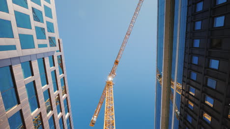 A-Huge-Construction-Crane-Near-Office-Buildings-With-Glass-Facades-City-Building-Steadicam-Shot