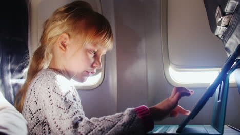 A-Girl-Enjoys-The-Tablet-In-The-Aircraft