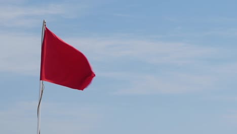 Red-Flag-On-A-Background-Of-Blue-Sky