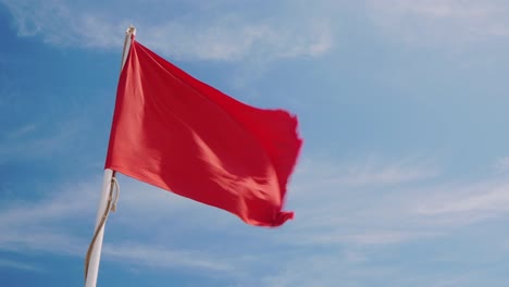 Red-Flag-On-A-Background-Of-Blue-Sky