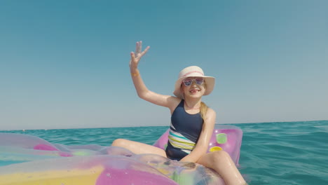 A-Girl-In-A-Hat-And-Sunglasses-Floats-In-The-Sea-On-An-Inflatable-Mattress-Merry-Vacation-Concept
