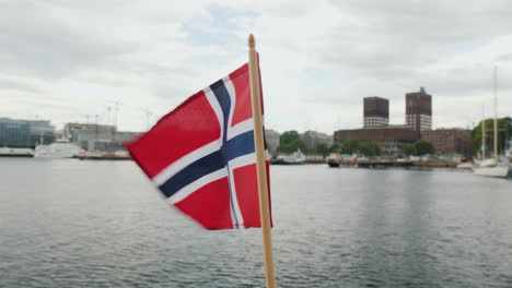 Walking-With-The-Flag-Of-Norway-Against-The-Background-Of-The-City-Line-Of-Oslo-Steadicam-Shot