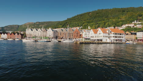 A-Street-Of-The-Famous-Colored-Wooden-Houses-In-Bergen-In-The-Foreground-A-Luxurious-Yacht