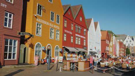 A-Street-With-Famous-Wooden-Houses-In-Bergen-Next-To-Summer-Cafes-Where-Many-Tourists-Rest