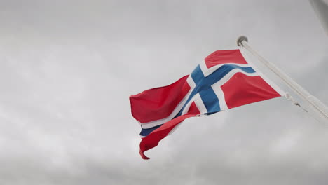 Flag-Of-Norway-Fluttering-Over-A-Stormy-Sky-Cruise-On-The-Fjords-Of-Norwayy-4k-Video