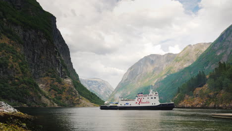 Cruise-Ship-With-Tourists-Approaches-The-Shore-Against-The-Backdrop-Of-The-Picturesque-Fjord-In-Norw