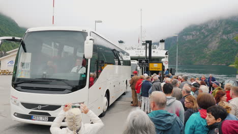 Buses-Cars-And-Tourists-Leave-The-Ferry-At-The-Shore-Of-The-Fjord-A-Group-Of-Other-People-And-Transp