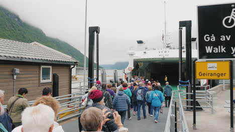 Buses-Cars-And-Tourists-Leave-The-Ferry-At-The-Shore-Of-The-Fjord-A-Group-Of-Other-People-And-Transp