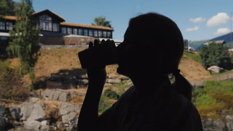 Silhouette-Of-Woman-Drinking-Coffee-By-The-Window-Sits-In-A-Cafe-High-In-The-Mountains-Of-Norway