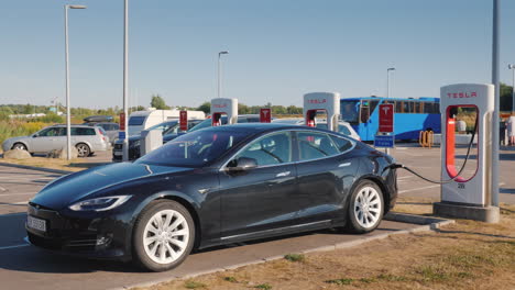 Die-Schwarze-Automarke-Tesla-Wird-An-Der-Kostenlosen-Marken-Schnellladestation-Geladen