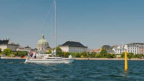 Die-Yacht-Mit-Der-Flagge-Von-Deutschland-Segelt-Vor-Dem-Hintergrund-Der-Stadtlinie-Euro-trip-Von-Kopenhagen