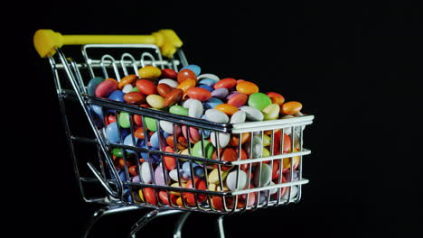 Sweets-In-A-Shopping-Trolley-On-A-Black-Background-4k-Video