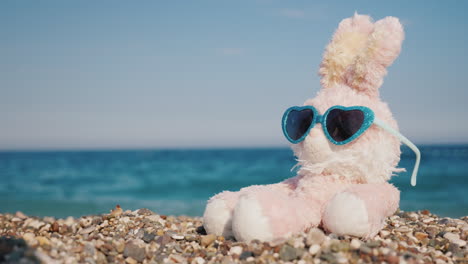 Plush-Rabbit-In-Sunglasses-Sunbathing-On-The-Beach-4k-Video