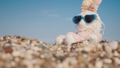 Plush-Rabbit-In-Sunglasses-Sunbathing-On-The-Beach-4k-Video