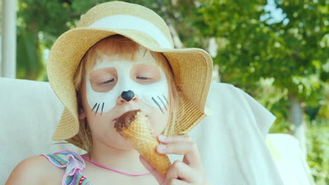A-Girl-With-Aquagrim-On-Her-Face-Eats-Ice-Cream-In-The-Resort-With-A-Child-Concept