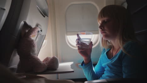 A-Girl-Drinks-Water-In-The-Cabin-Of-The-Plane-4k-Video