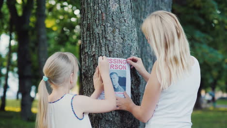 A-Woman-With-A-Child-Is-Attached-To-The-Tree-Flyer-With-Information-About-The-Missing-Man