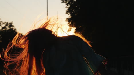 Girl-With-Long-Hair-Having-Fun-At-Sunset-Waving-Her-Head-Playing-With-Her-Hair-In-The-Sun's-Rays