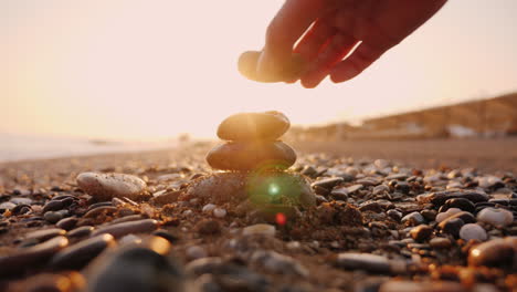 Hand-Puts-Stones-In-The-Pyramid-The-Sun's-Rays-Shine-Through-His-Fingers