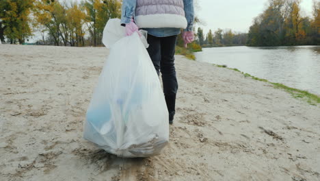 A-Volunteer-Child-Drags-A-Heavy-Garbage-Bag-Along-The-Beach-Cleaning-Of-Waste-And-Activism-Follow-Sh