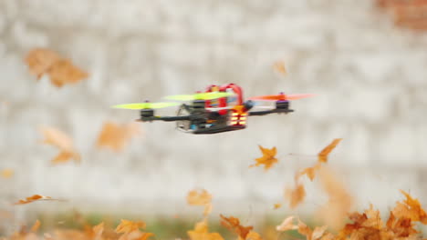 Die-Drohne-Fliegt-Schnell-Und-Tief-über-Dem-Boden-Und-Hebt-Im-Wind-Blätter-Vom-Boden