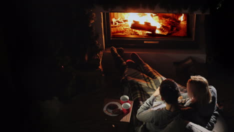 Young-Couple-Relaxing-At-Home-By-The-Fireplace-Comfortable-Warm-Home-Concept