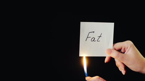 Man-Burns-A-Paper-With-The-Inscription-Fat