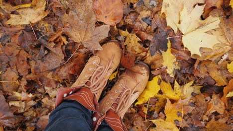 Feet-In-Autumn-Boots-On-Fallen-Autumn-Leaves-The-Camera-Rotates