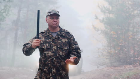 Portrait-Of-An-Angry-Security-Guard-In-Camouflage-Uniform-With-A-Rubber-Baton-In-His-Hands