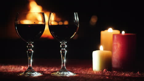 Two-Glasses-With-Red-Wine-Against-The-Background-Of-The-Fireplace-Where-The-Fire-Is-Burning