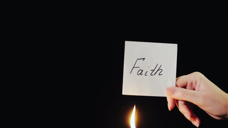 Man-Burns-A-Paper-With-The-Inscription-Faith