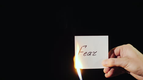 Man-Burns-A-Paper-With-The-Inscription-Fear