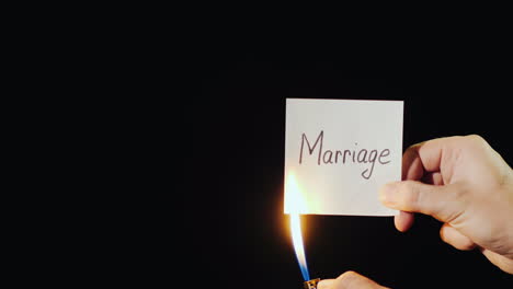 Hand-Holds-Burning-Paper-With-Inscription-Marriage