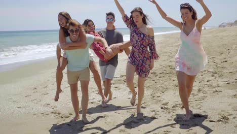 Group-of-young-friends-frolicking-on-a-beach