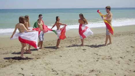 Group-of-Friends-in-Swim-Suits-with-Flags-at-Beach