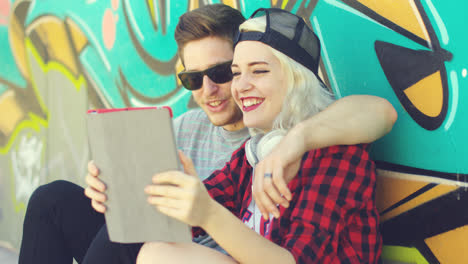 Laughing-young-hipster-couple-checking-a-tablet