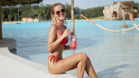 Optimistic-lady-enjoying-drink-on-poolside
