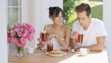 Couple-drinking-iced-tea-at-breakfast-outside